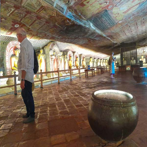 A tourist using a travel guidebook for self-guiding through the historic rock shrines at Dambulla Cave Temple.