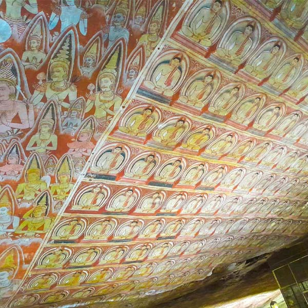 Intricate ancient ceiling frescoes inside the Dambulla Cave Temple, showcasing colorful traditional Buddhist art and murals