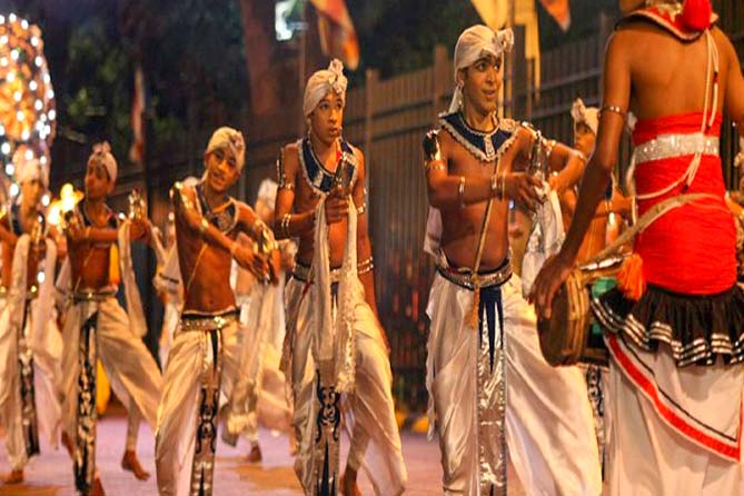 Dancers performing with traditional hand bells during the Kandy procession.