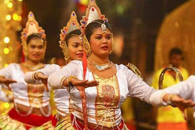 Female dancers in traditional attire performing during the Kandy Esala Perahera.