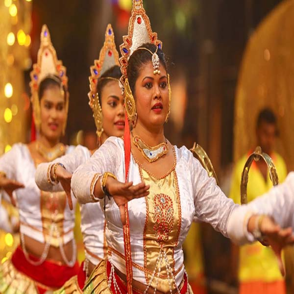 Female Kandyan dancers wearing exquisite golden headdresses and traditional white costumes performing during the Kandy Esala Perahera