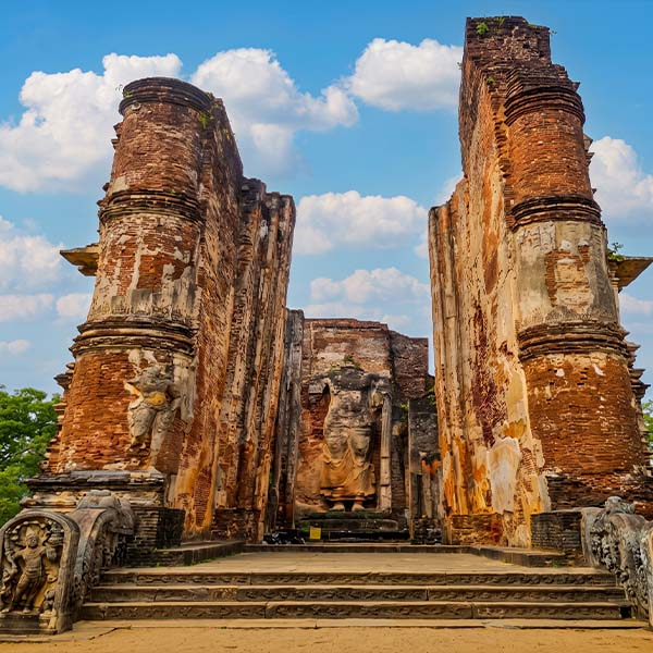 The towering ancient brick walls of the Lankatilaka Image House in Polonnaruwa, revealing the remains of a massive standing Buddha statue inside