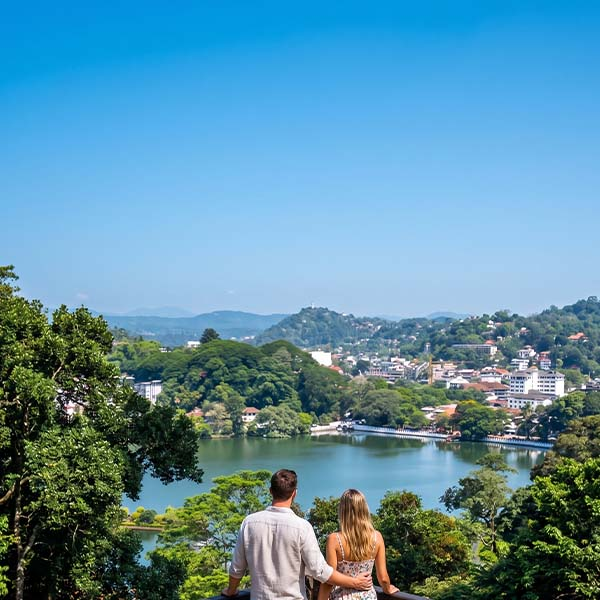 Kodimale Viewpoint: A couple standing at a scenic overlook, looking out over Kandy Lake, the Temple of the Tooth, and the surrounding city from within Udawatta Kele Sanctuary.