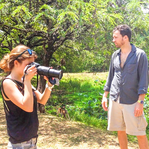 A female visitor is taking a picture of a monkey