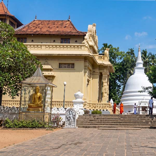 Buddhist pilgrims and visitors walking around the stupa and sacred grounds at Kelaniya Raja Maha Vihara near Colombo
