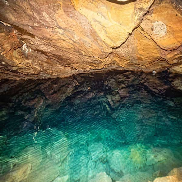 Glow of the subterranean blue water pool inside Nil Diya Pokuna cave near Ella, Sri Lanka