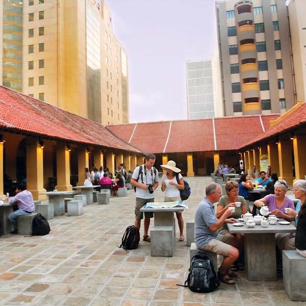 Tourists enjoying coffee and refreshments in the open courtyard of the historic Old Dutch Hospital in Colombo Fort