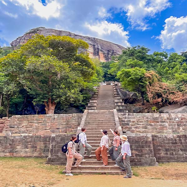 Four female travelers exploring the stone ruins and pathways at the Yapahuwa Rock Fortress in Sri Lanka.