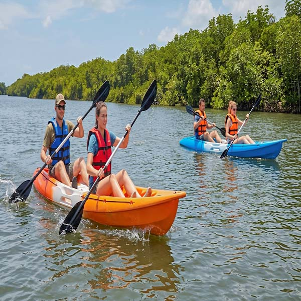 Travelers kayaking on the serene waters of the Kala Oya river, surrounded by lush mangrove forests near Wilpattu National Park in Gange Wadiya, Sri Lanka.